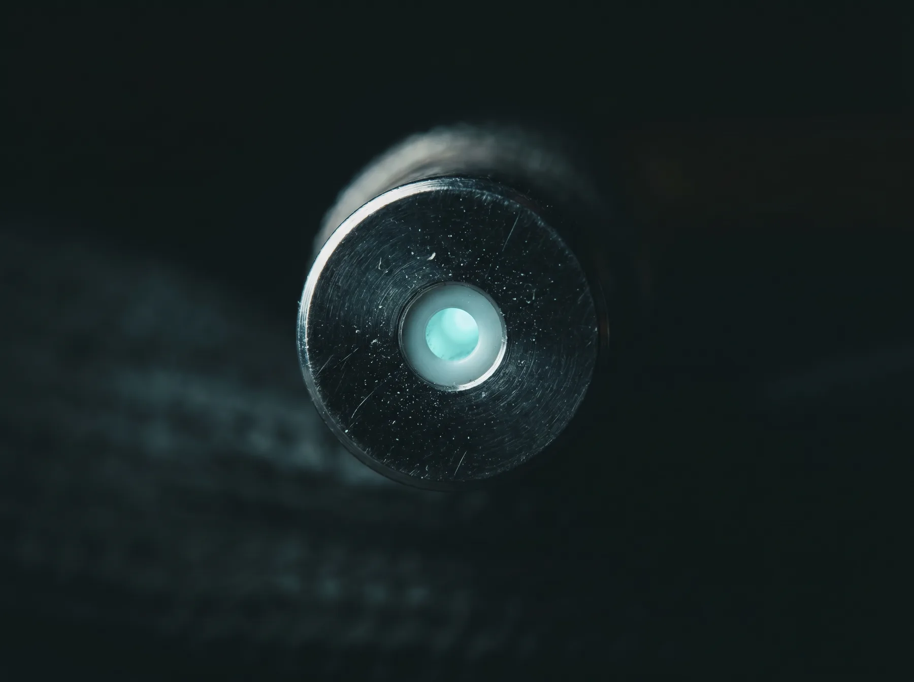 Macro photograph of a fiber optic connector end-face, magnified to show the polished ferrule and core